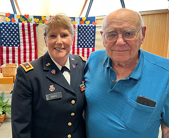 Beth Davis in army uniform posing with veteran